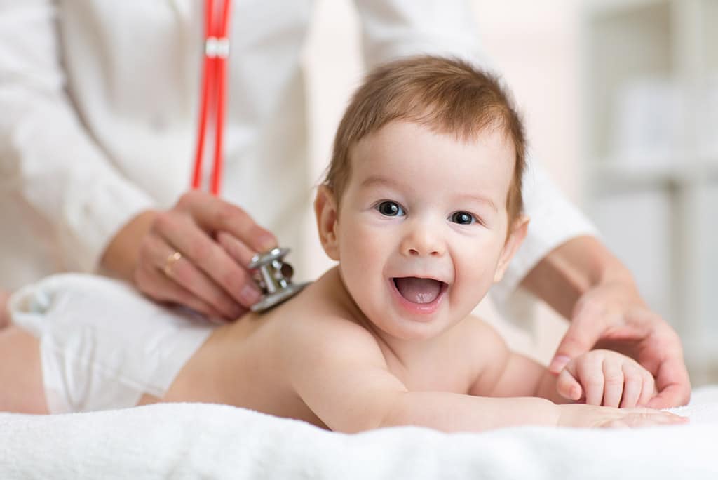 New born smiling while examined by the Pediatrician.